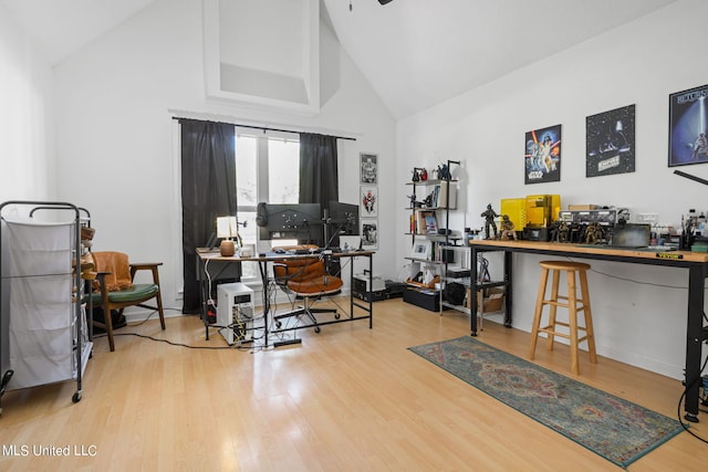 home office featuring high vaulted ceiling and light hardwood / wood-style flooring