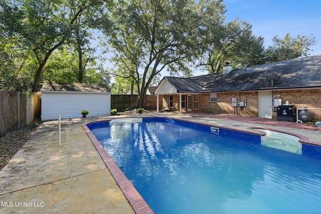 view of swimming pool featuring a patio area and an outbuilding