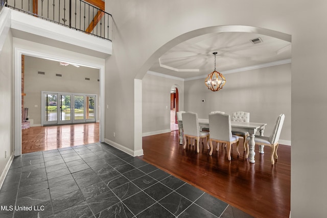 445 Carey Chapel Rd, Red Banks, MS 38661 - dining space featuring arched walkways, a chandelier, crown molding, dark wood finished floors, and a high ceiling