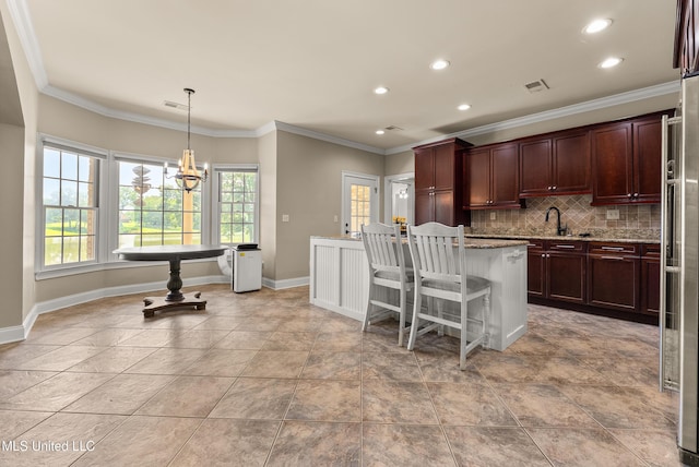 445 Carey Chapel Rd, Red Banks, MS 38661 - kitchen with recessed lighting, tasteful backsplash, an island with sink, light stone counters, and hanging light fixtures