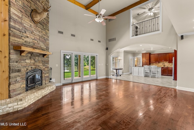 445 Carey Chapel Rd, Red Banks, MS 38661 - unfurnished living room featuring a ceiling fan, arched walkways, hardwood / wood-style floors, a high ceiling, and beam ceiling