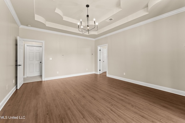 445 Carey Chapel Rd, Red Banks, MS 38661 - empty room featuring a tray ceiling, a chandelier, ornamental molding, and wood finished floors