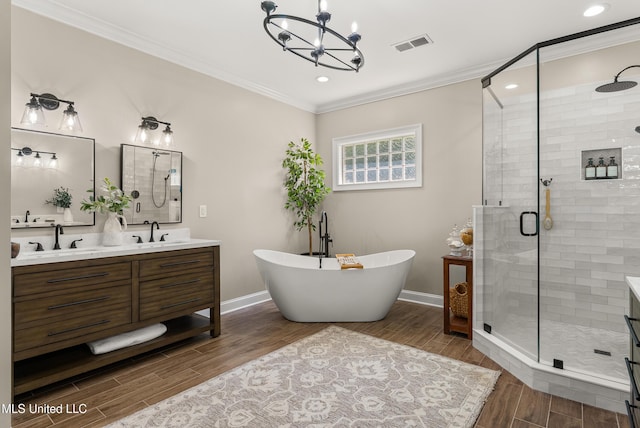 445 Carey Chapel Rd, Red Banks, MS 38661 - bathroom with double vanity, crown molding, a stall shower, a freestanding tub, and a chandelier