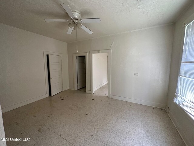 315 S Bolivar Ave, Cleveland, MS 38732 - spare room featuring light floors, ceiling fan, a textured ceiling, and baseboards