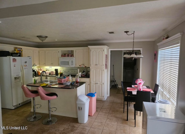 kitchen with a breakfast bar, ornamental molding, pendant lighting, sink, and white appliances