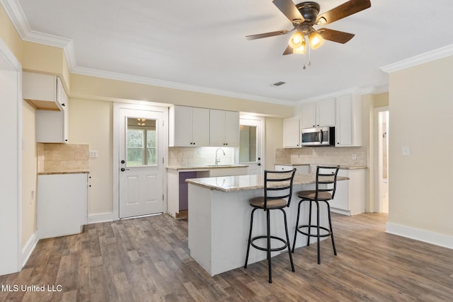 kitchen featuring dark hardwood / wood-style flooring, a center island, and white cabinets