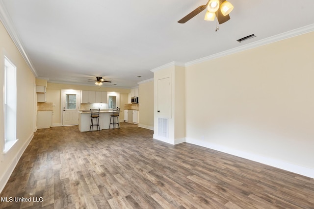 unfurnished living room featuring crown molding, ceiling fan, and hardwood / wood-style flooring