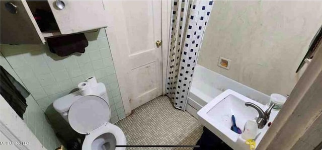 full bathroom featuring tile walls, toilet, vanity, shower / tub combo with curtain, and tile patterned flooring