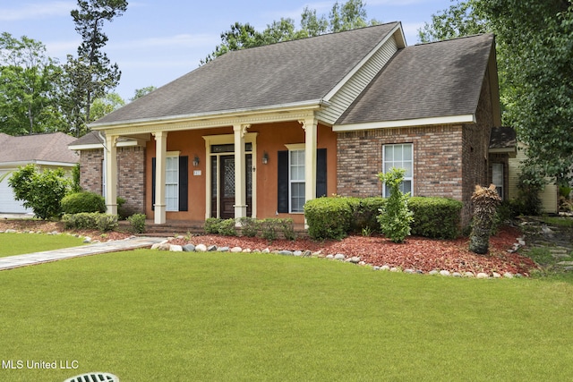 ranch-style home featuring brick siding, roof with shingles, covered porch, and a front yard