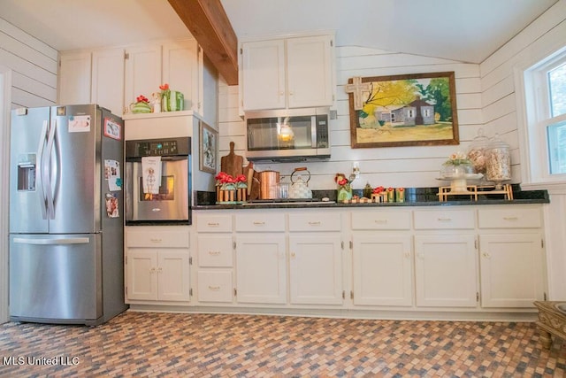 65 Vaiden Dr, Hernando, MS 38632 - kitchen featuring appliances with stainless steel finishes, white cabinets, wooden walls, and lofted ceiling