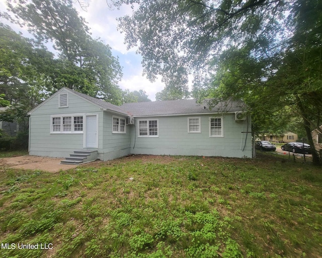 rear view of property featuring a yard