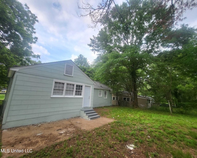 rear view of property featuring a lawn