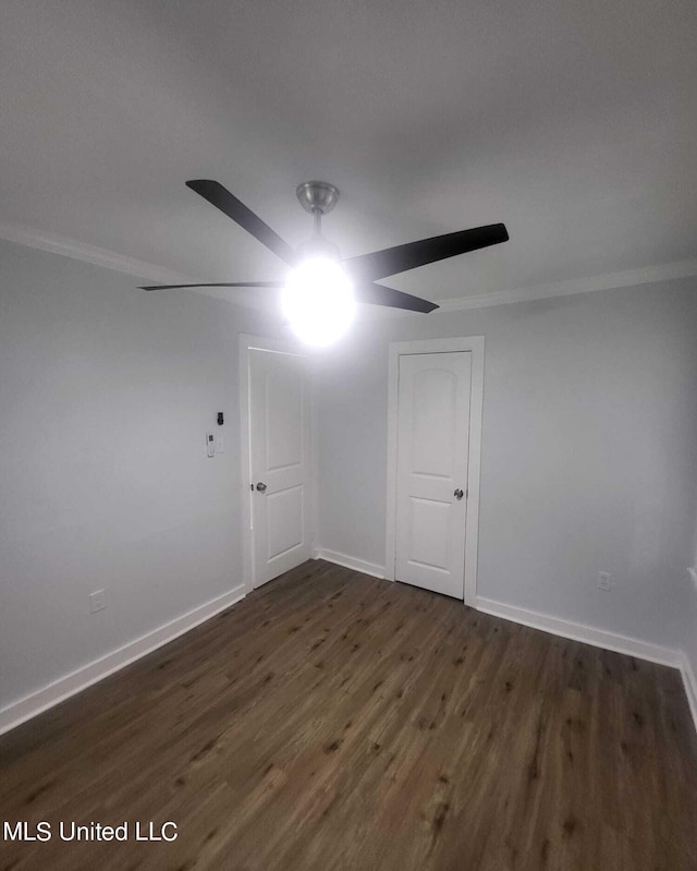 spare room with dark wood-type flooring, ceiling fan, and ornamental molding