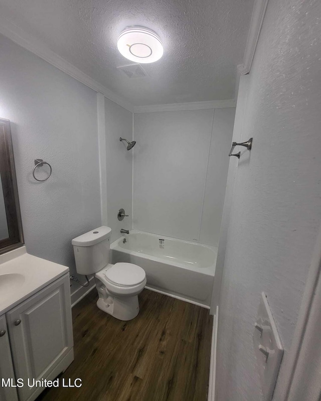 full bathroom with a textured ceiling, hardwood / wood-style floors, toilet, shower / tub combination, and vanity