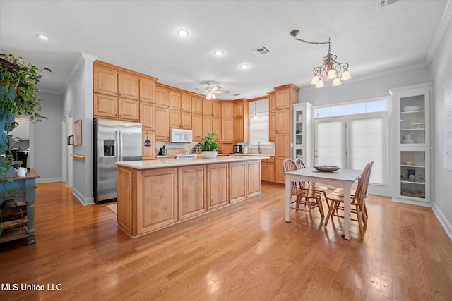 25 Savannah Cir, Brandon, MS 39047 - kitchen with stainless steel refrigerator with ice dispenser, white microwave, ornamental molding, ceiling fan, and light wood-style flooring