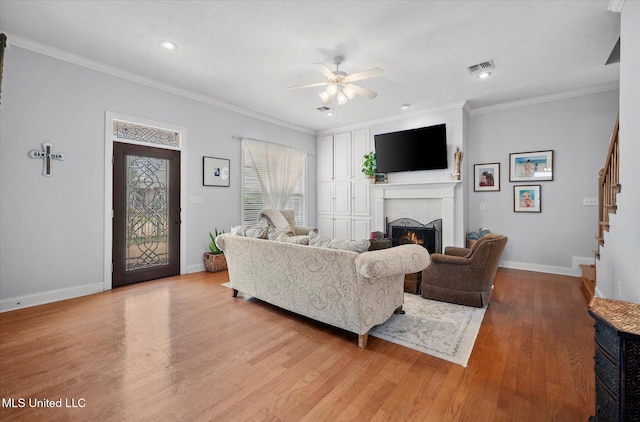 25 Savannah Cir, Brandon, MS 39047 - living area with a lit fireplace, a ceiling fan, stairs, light wood-style floors, and baseboards
