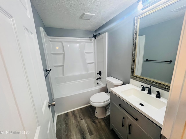 full bathroom featuring tub / shower combination, vanity, a textured ceiling, hardwood / wood-style flooring, and toilet