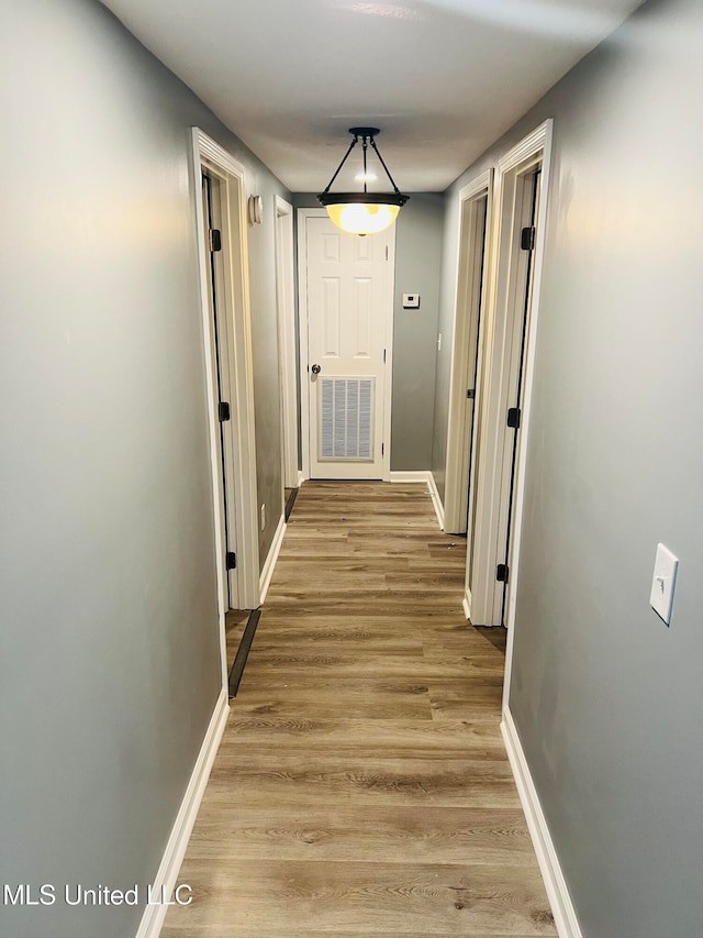 hallway with light hardwood / wood-style floors