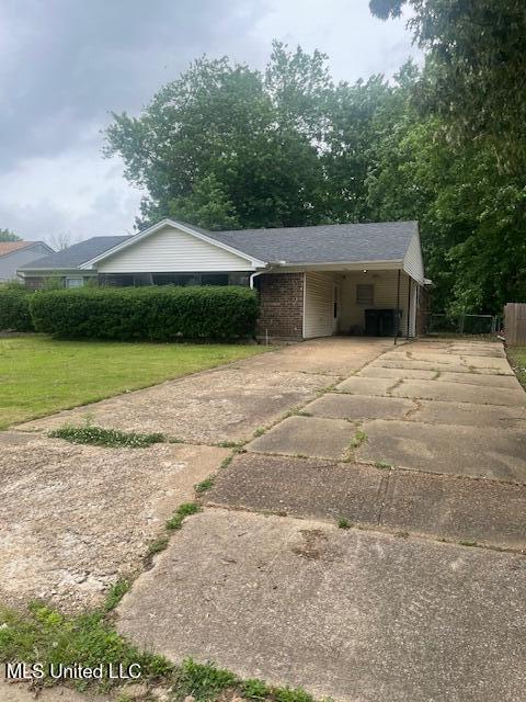 exterior space with driveway, a front yard, and a carport