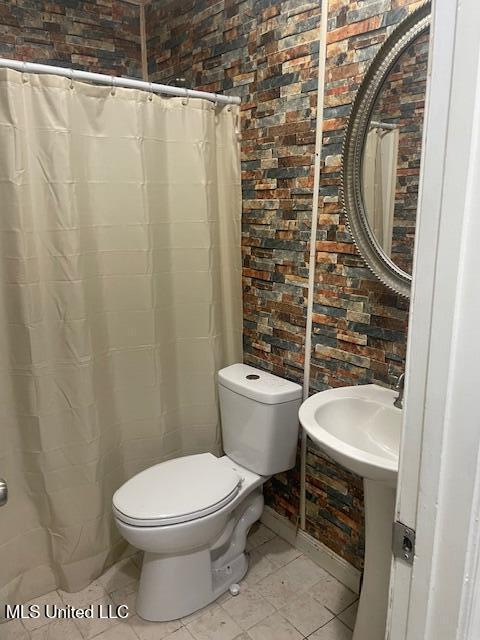 bathroom with toilet and tile patterned flooring