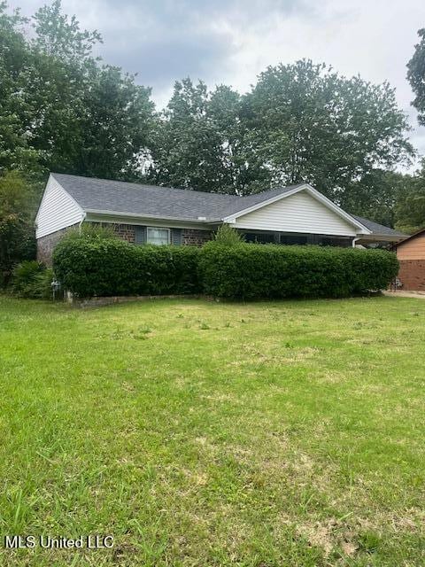 single story home with a front yard and brick siding