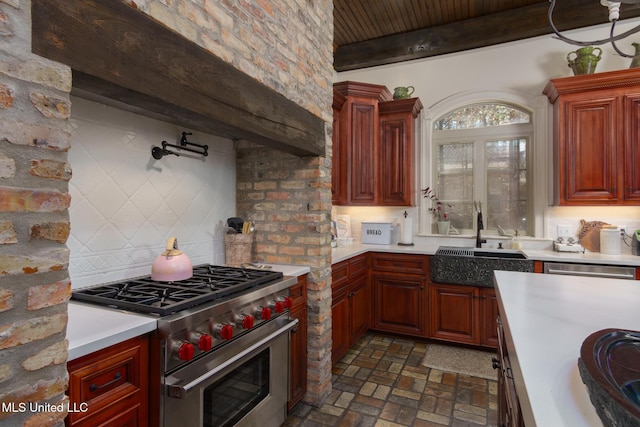 kitchen with light countertops, brick floor, a sink, and stainless steel stove