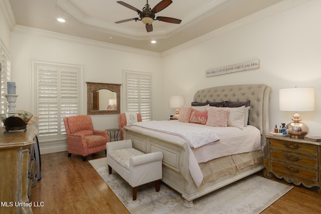 bedroom featuring recessed lighting, a raised ceiling, ornamental molding, ceiling fan, and wood finished floors