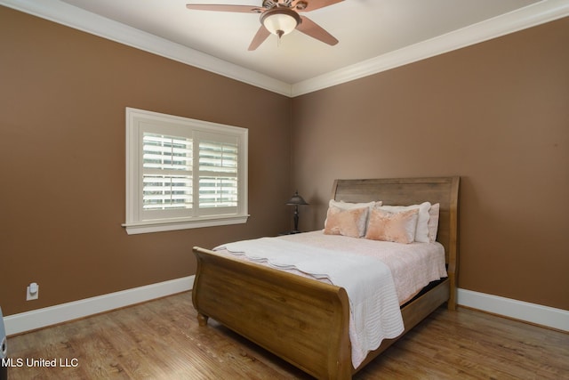 bedroom with ornamental molding, wood finished floors, a ceiling fan, and baseboards