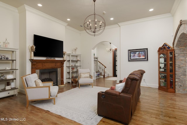 living room with an inviting chandelier, stairs, a fireplace, and light wood-style flooring