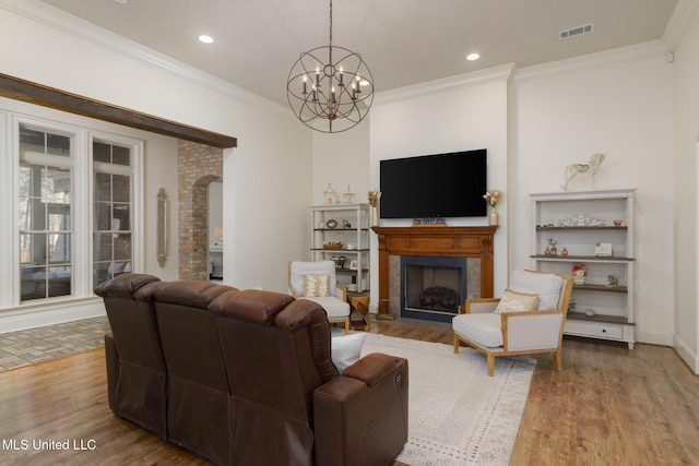 living room with arched walkways, ornamental molding, wood finished floors, and visible vents