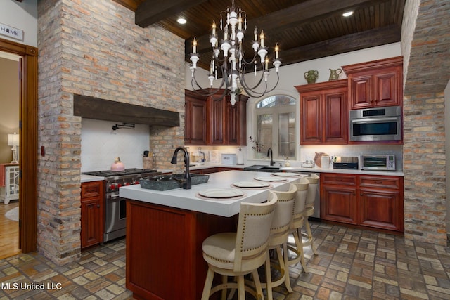 kitchen with light countertops, appliances with stainless steel finishes, a kitchen island with sink, and tasteful backsplash