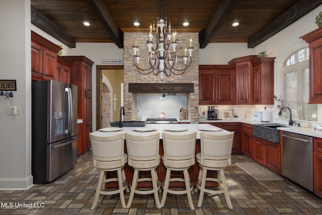 kitchen with a center island, stainless steel appliances, light countertops, wood ceiling, and a sink