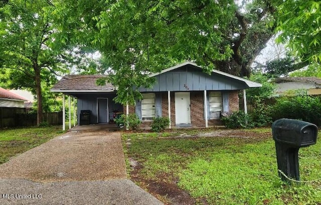 view of front of property featuring concrete driveway, brick siding, a carport, and board and batten siding