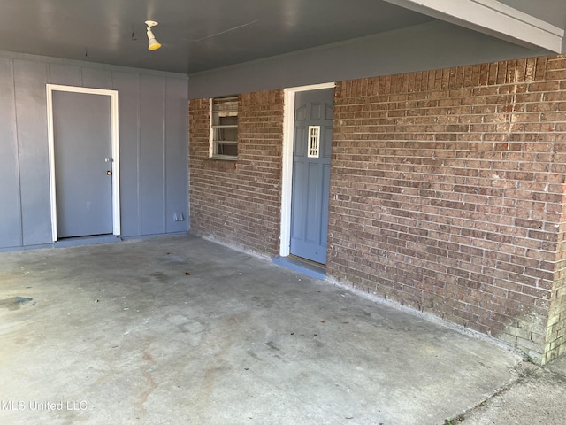 doorway to property featuring brick siding and board and batten siding