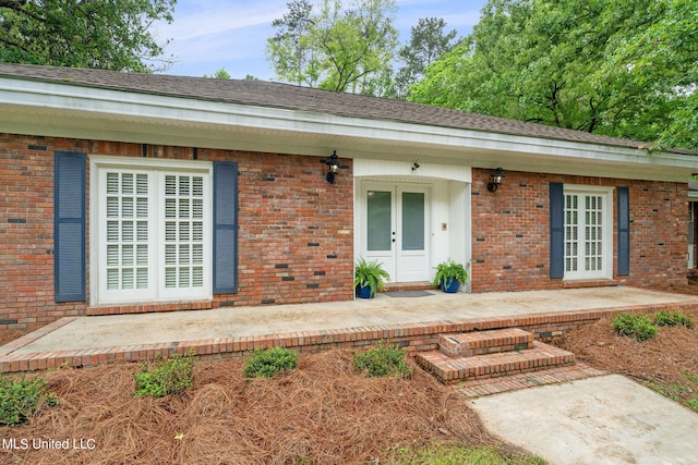 view of exterior entry featuring a patio and french doors