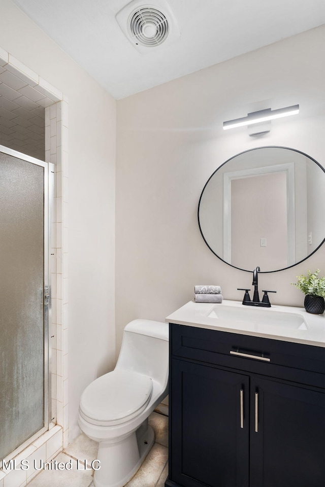 bathroom featuring toilet, vanity, tile patterned floors, and a shower with door