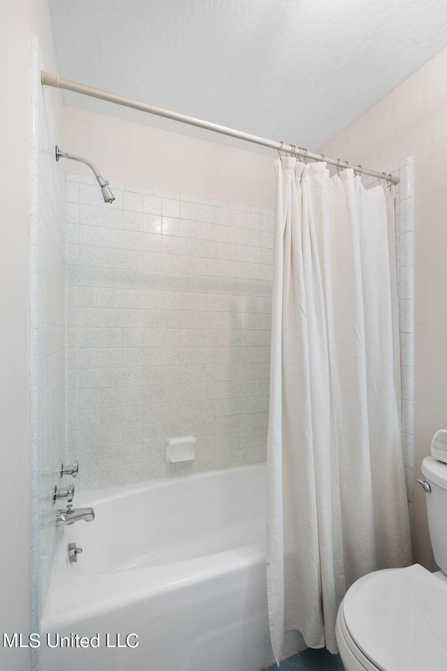 bathroom featuring shower / bath combo with shower curtain and toilet