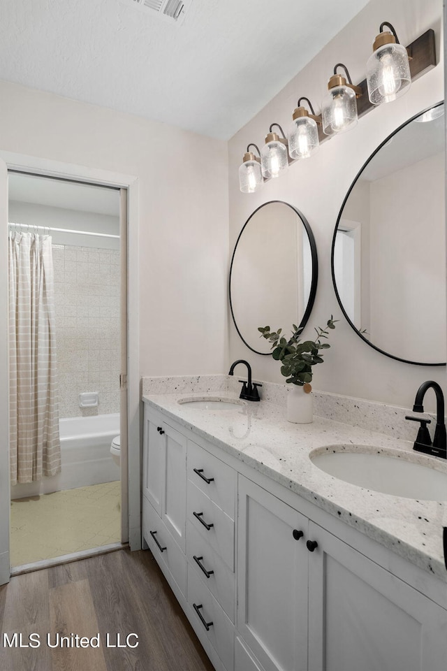 full bathroom with vanity, toilet, shower / bath combo, and hardwood / wood-style floors