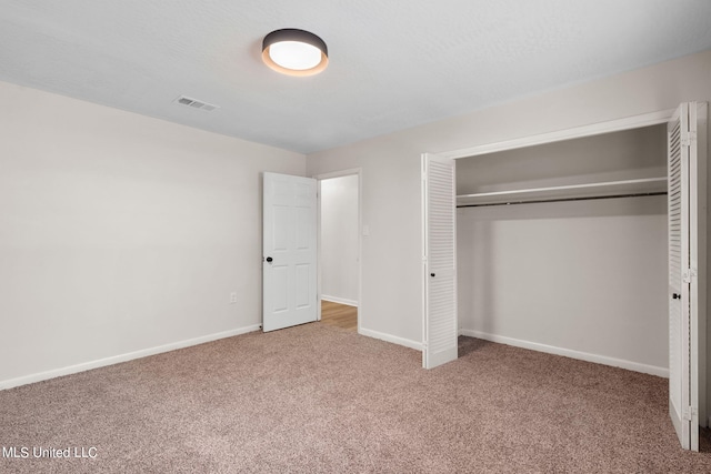 unfurnished bedroom with carpet and a closet