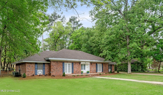 ranch-style house featuring central AC and a front lawn