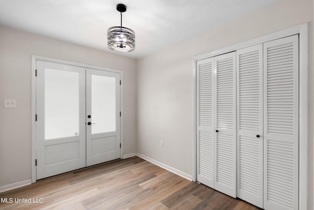 foyer with light hardwood / wood-style flooring and french doors