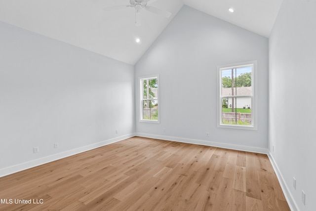 unfurnished room with light hardwood / wood-style floors, a healthy amount of sunlight, high vaulted ceiling, and ceiling fan