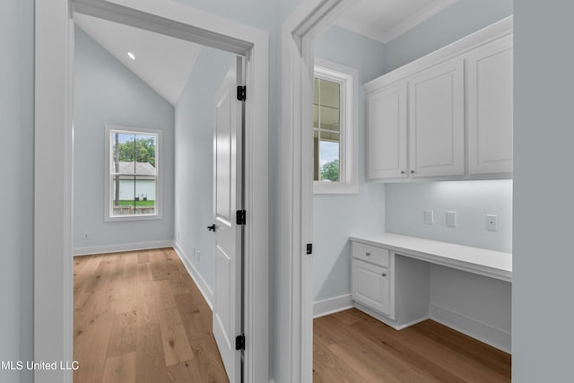 hallway with lofted ceiling and light wood-type flooring