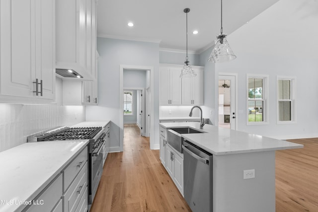 kitchen featuring white cabinets, an island with sink, sink, pendant lighting, and stainless steel appliances