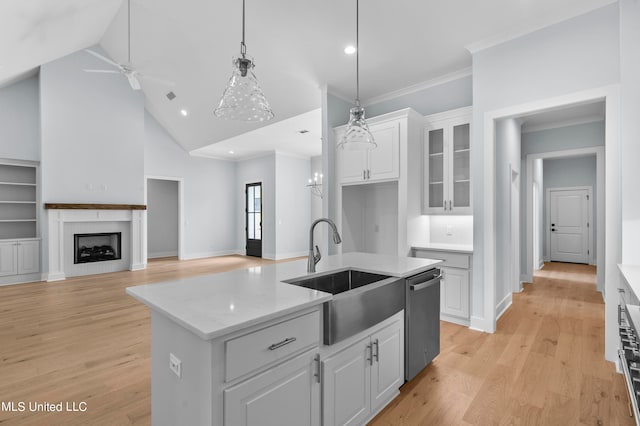 kitchen with sink, dishwasher, an island with sink, light hardwood / wood-style floors, and white cabinets