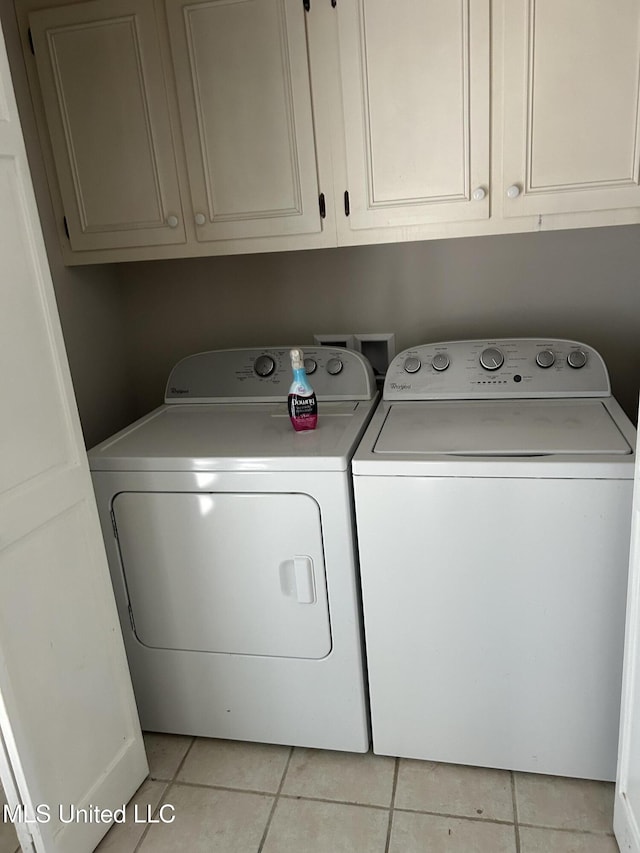 laundry room with independent washer and dryer and light tile patterned flooring