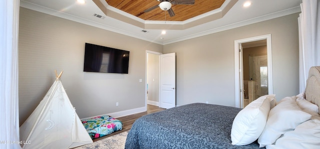 bedroom with a raised ceiling, visible vents, ornamental molding, wood finished floors, and baseboards