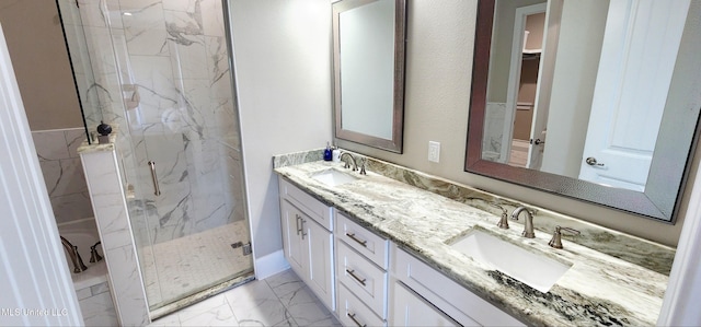 bathroom with marble finish floor, a sink, a marble finish shower, and double vanity