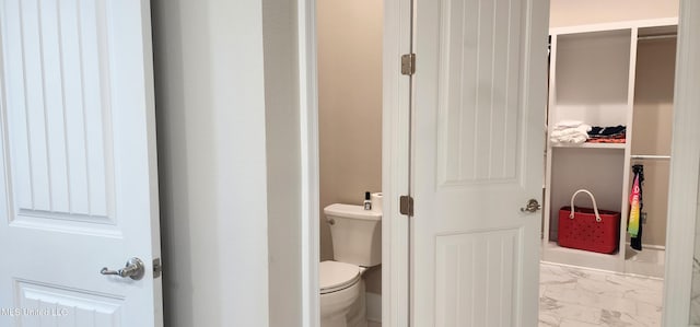 bathroom featuring marble finish floor and toilet