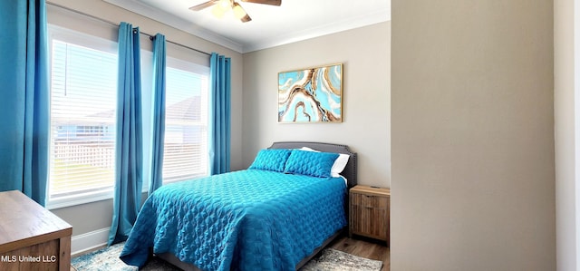 bedroom with ceiling fan, baseboards, crown molding, and wood finished floors